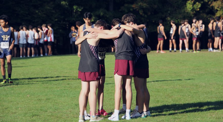 A team of cross-country runners huddled together before competing