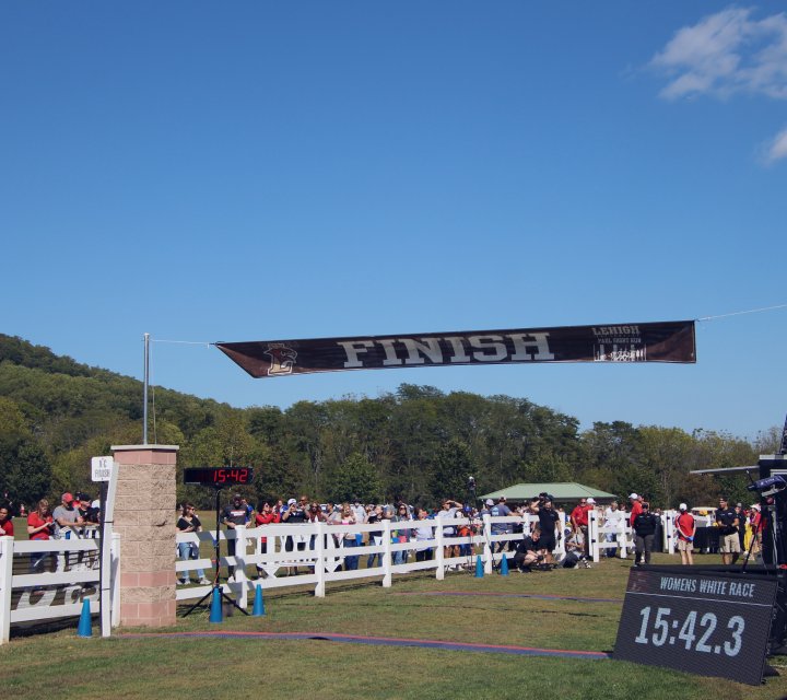Athletes crossing the finish line under a race banner